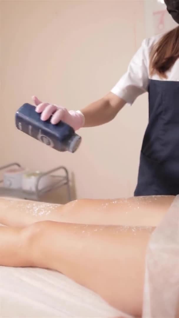 Depilação de açúcar. O mestre de depilação retira o cabelo de umas pernas de mulher — Vídeo de Stock