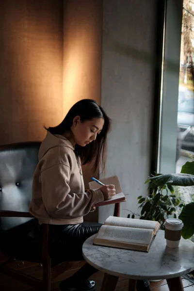 Asian female student performs homework — Fotografia de Stock