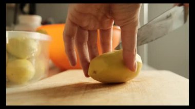 Mutfaktaki masada sebze kesen kadın.