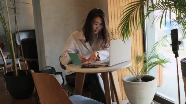 Aziatische vrouwelijke freelancer werken in een cafe — Stockvideo