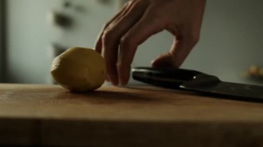 Mutfaktaki masada sebze kesen kadın.