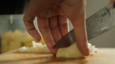 Mutfaktaki masada sebze kesen kadın.