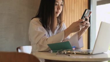 Bir kafede çalışan Asyalı serbest çalışan bir kadın.