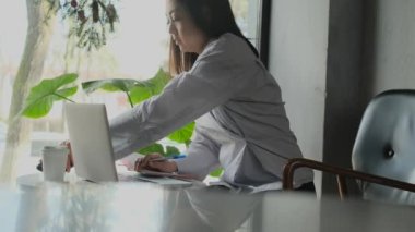 Bir kafede çalışan Asyalı serbest çalışan bir kadın.
