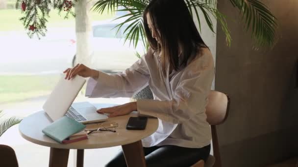 Ázsiai női szabadúszó dolgozik egy kávézóban — Stock videók