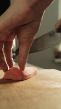 Mutfaktaki masada sebze kesen kadın.