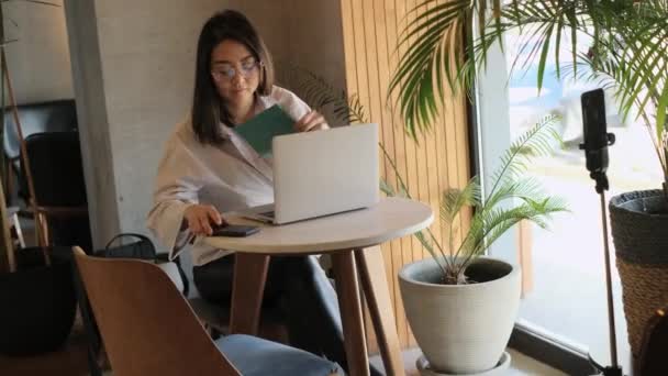 Ασιάτισσα ελεύθερη επαγγελματίας που εργάζεται σε καφετέρια — Αρχείο Βίντεο