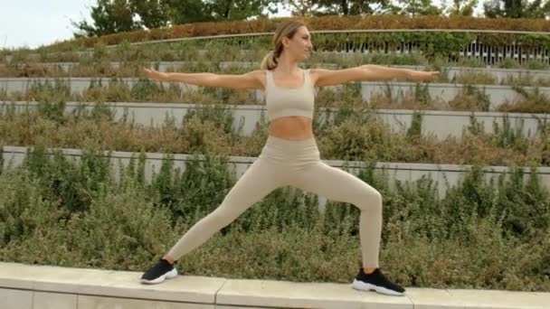 En kvinna gör yoga i parken — Stockvideo