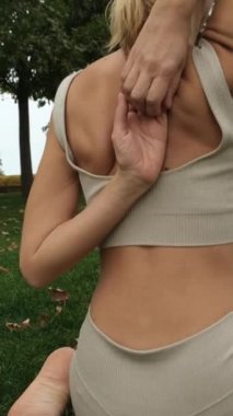 Bir kadın parkta yoga yapıyor.