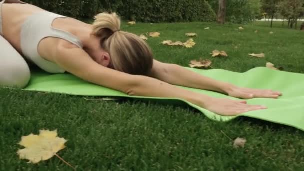 Egy nő jógázik a parkban. — Stock videók
