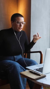 Gözlüklü bir kadın video bağlantısıyla konuşuyor