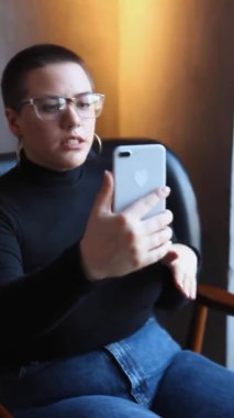 Gözlüklü bir kadın video bağlantısıyla konuşuyor