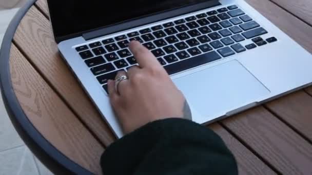 Seorang wanita duduk di kafe dan bekerja di laptop. — Stok Video