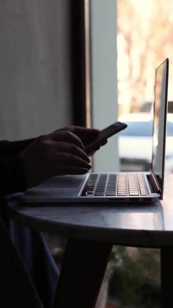 Egy nő ül egy kávézóban és egy laptopnál dolgozik.. — Stock videók