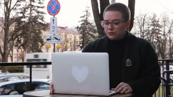 Žena sedí v kavárně a pracuje v laptopu. — Stock video