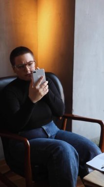 Kadının biri telefonundan selfie çekiyor.