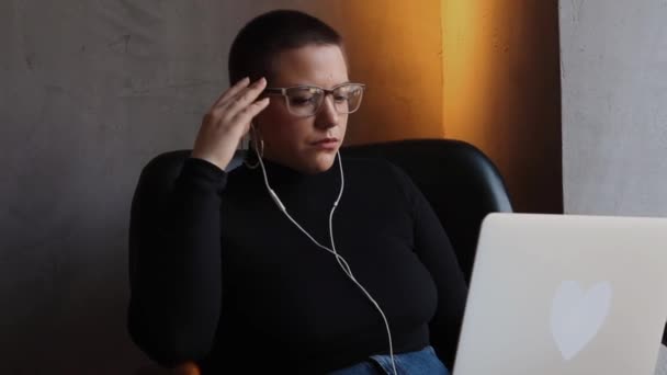 Женщина в очках разговаривает по видеосвязи — стоковое видео