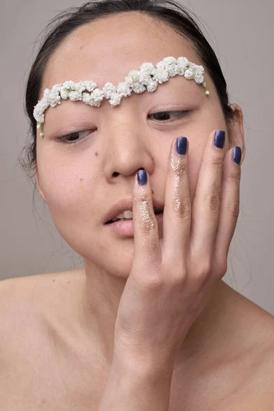 Азійка з квітами на обличчі. — стокове фото