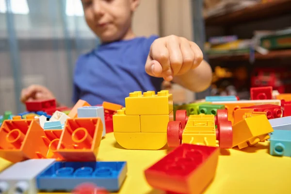 Un niño hermoso está jugando en casa con bloques de construcción. Fotos de stock libres de derechos