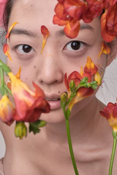 Mujer asiática con flores en la cara Fotos de stock