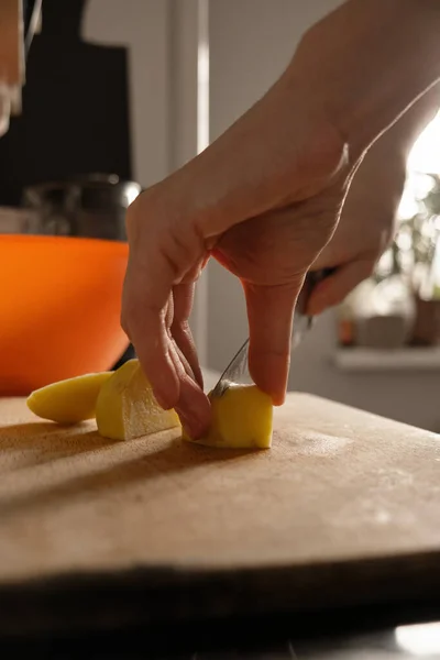 Woman cutting vegetable on table in kitchen Stock Kép