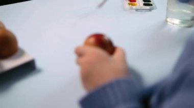 Küçük bir çocuk paskalya yumurtası boyuyor..