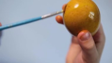 Küçük bir çocuk paskalya yumurtası boyuyor..
