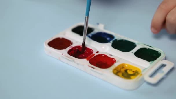 Enfant peignant un tableau avec des couleurs de l'eau Gros plan — Video