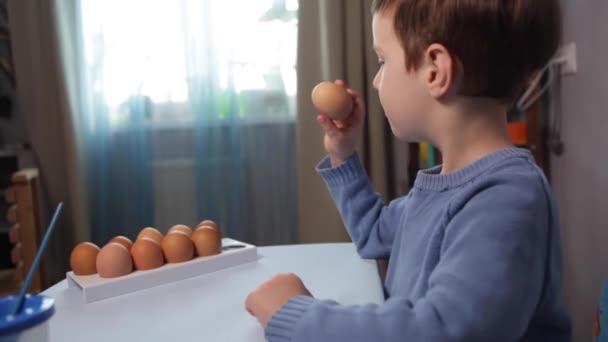 Un niño pequeño pinta un huevo de Pascua. — Vídeos de Stock