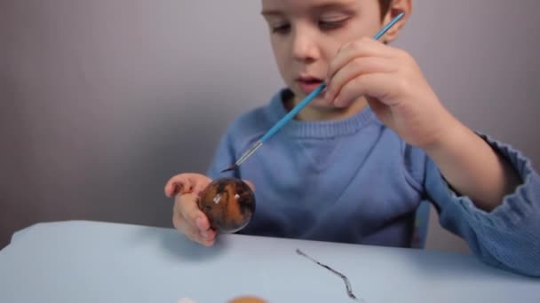 Küçük bir çocuk paskalya yumurtası boyuyor.. — Stok video