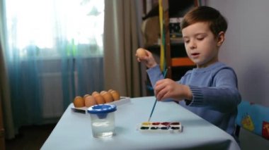 Küçük bir çocuk paskalya yumurtası boyuyor..