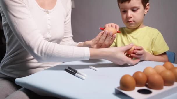 Un niño y mamá pintan un huevo de Pascua. — Vídeos de Stock