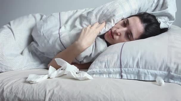 Žena leží v posteli a fouká si nos — Stock video