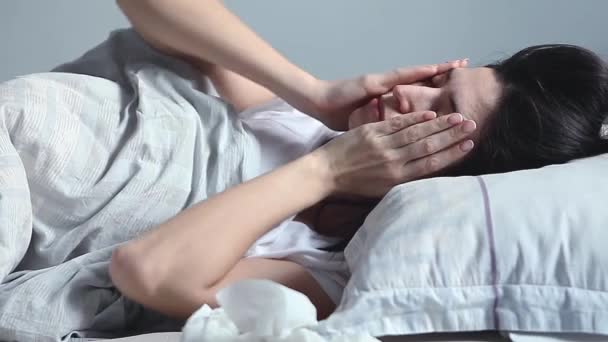 Kvinna som ligger i sängen och har feber — Stockvideo