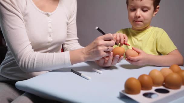 Egy kisgyerek és anya húsvéti tojást fest.. — Stock videók
