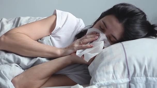 Mujer acostada en la cama y sonándose la nariz — Vídeos de Stock