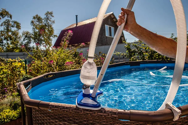 cleaning the pool with a vacuum cleaner. Cleaning equipment for small pools.