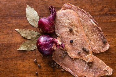Eski ahşap bir masada baharatlı, soğanlı ve otlu kurutulmuş et. Bira çerezi. Kartvizitler, kartlar ve posterler için arka plan. Boşluğu kopyala.