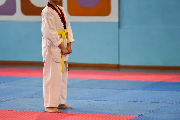 跆拳道的孩子跆拳道比赛中 一名身穿跆拳道制服 系着黄色腰带的男孩站在那里 — 图库照片