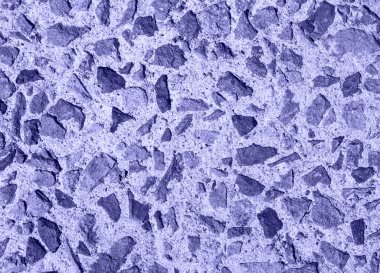 Beton zeminde küçük çakıl taşları. Yukarıdan vurulmuş. Fotoğraf tonu yılın renginde çok peri.