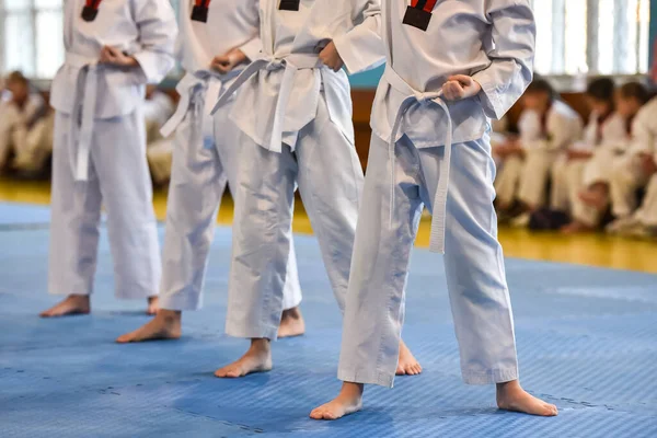 跆拳道的孩子男子运动员穿着跆拳道制服 系着白腰带站在跆拳道锦标赛上 — 图库照片