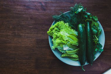 fresh cucumbers, lettuce, dill, cilantro and green peas. Spring salad, spring greens, healthy food from natural products. Vegetarian food. Vintage tone.