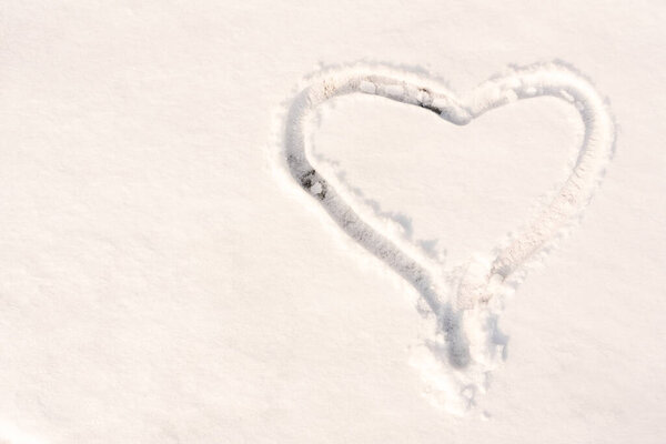 The symbol of the heart, painted on the fresh white snow with copy space.