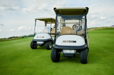 Golf sahasında iki golf arabası.
