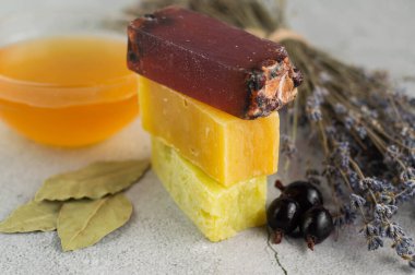 Gri arkaplandaki doğal malzemelerden yapılan farklı sabunların bulanık görüntüleri.