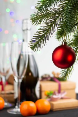 Ön planda arka planda oyuncak olan bir ladin filizi, bulanık bir bardak ve şampanya resmi, hediyeler. Yeni yıl kartı..