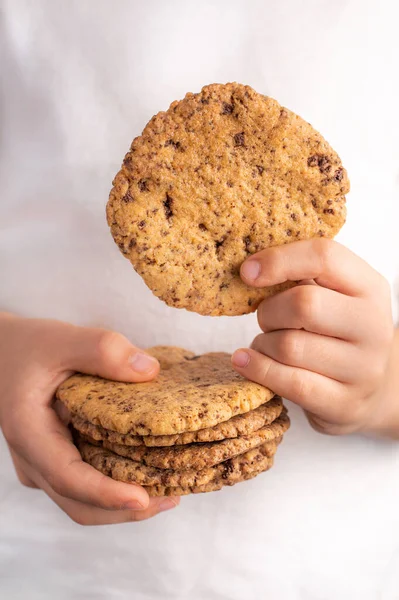 明るい背景に子供の手の中にチョコレートチップと自家製クッキーのぼやけたイメージ — ストック写真