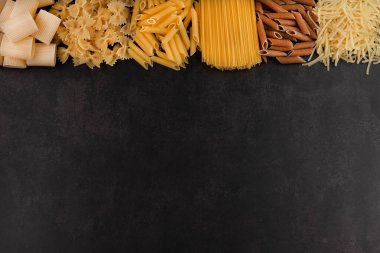 Spagetti, rigatto makarna, penne, farfalle, makarna, canelonni siyah bir arkaplanda yazı yazmak için yer var..