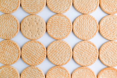 Kurabiyeler beyaz arka planda sırayla dizilir. Kalorili yiyecekler..