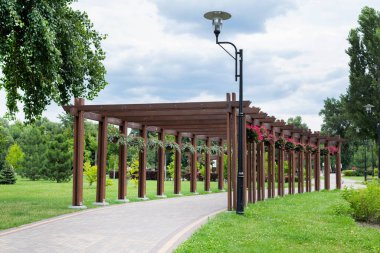 Parktaki bitkilerle birlikte pergolaların bulanık görüntüsü. Parkta yaz günü.